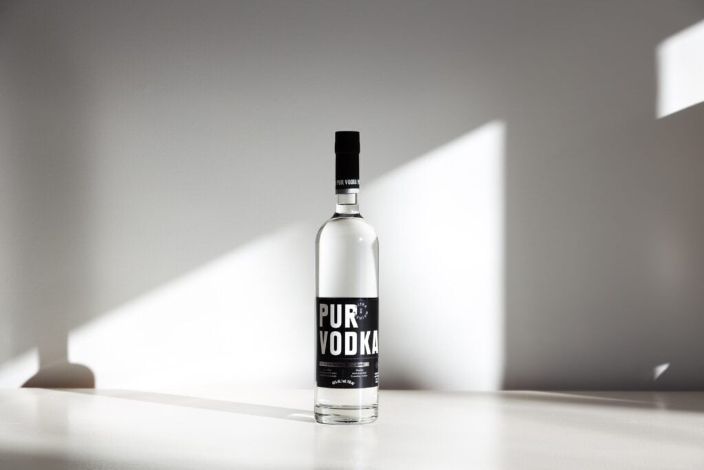 Bottle of most awarded Canadian vodka, Pur Vodka, set in rays of light on plain white background